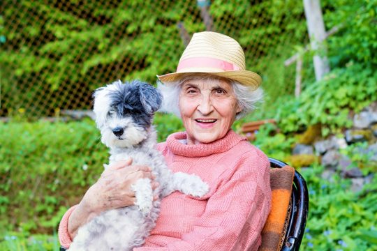Retired woman sitting with her dog