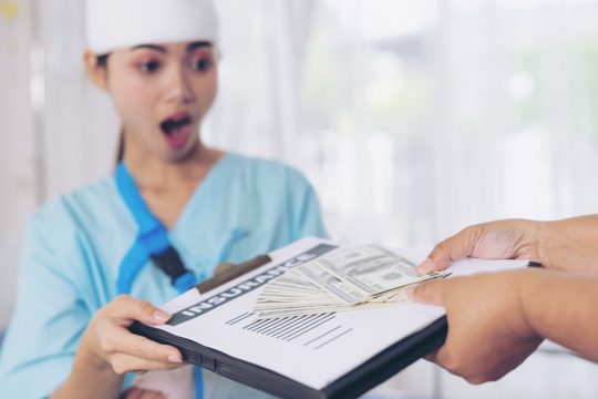 Accident patients injury  woman on patient's bed in hospital  holding us dollar bills feel happy from getting insurance money from insurance companies- medical concept