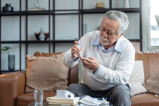 Old senior asian male hand nasal swab testing rapid tests by himself for detection of the sars co2 virus at home isolate quarantine concept