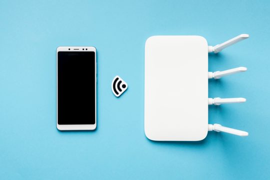 Top view of wi-fi router with smartphone