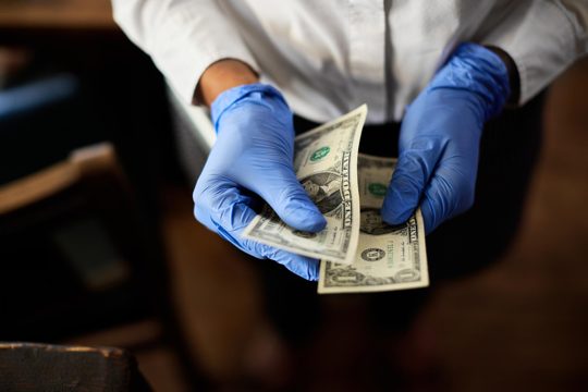 Closeup of waitress counting tips at the end of her shift in a cafe