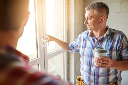 Handsome young carpenter working with an experienced man