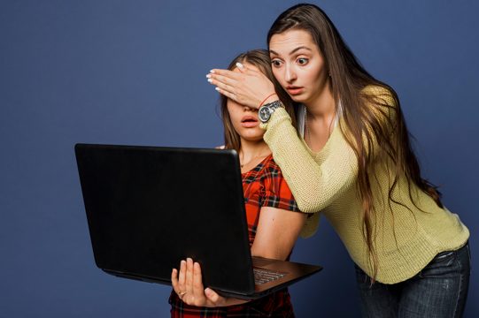 Medium shot shocked girls with laptop