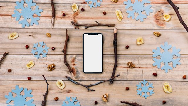 Smartphone between twigs and decorative snowflakes
