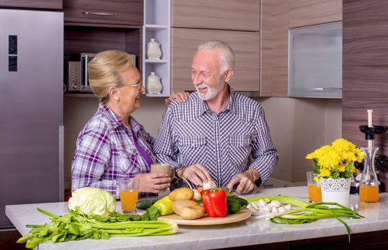 Beautiful elderly couple cooking in the kitchen with each other