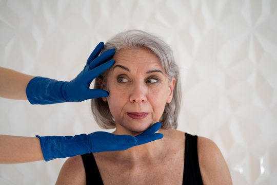 Front view hands with gloves touching woman's face