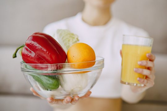 Nutritionist showing juice and vegetable bowl