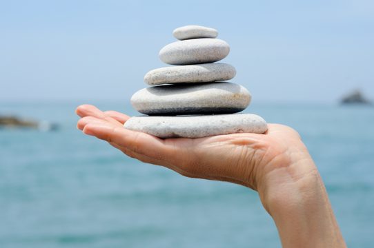 Hand holding a pile of pebbles