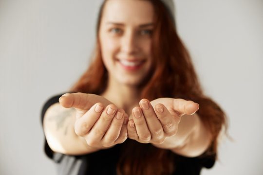 Young woman holding open palms