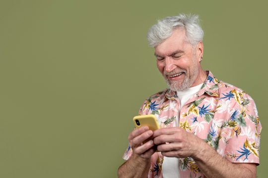Medium shot senior man holding smartphone