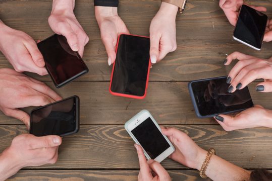 Group of friends using smartphones