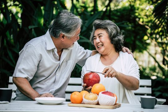 Elderly couples playing and eating some fruit