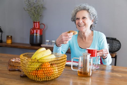 Happy senior lady enjoying dessert